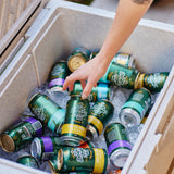 Person reaching into a cooler filled with iced cans of sunday road beer from the sutherland shire