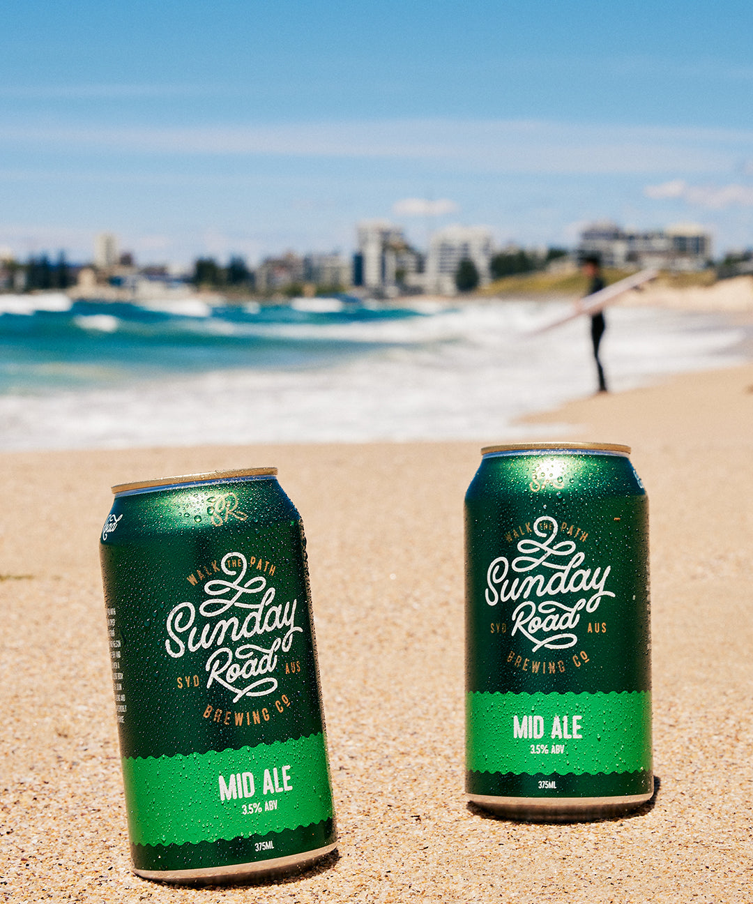 perfect surf beer Sunday Road Brewing Mid Ale on a sandy beach with ocean at wanda beach cronulla