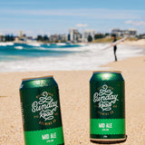 perfect surf beer Sunday Road Brewing Mid Ale on a sandy beach with ocean at wanda beach cronulla