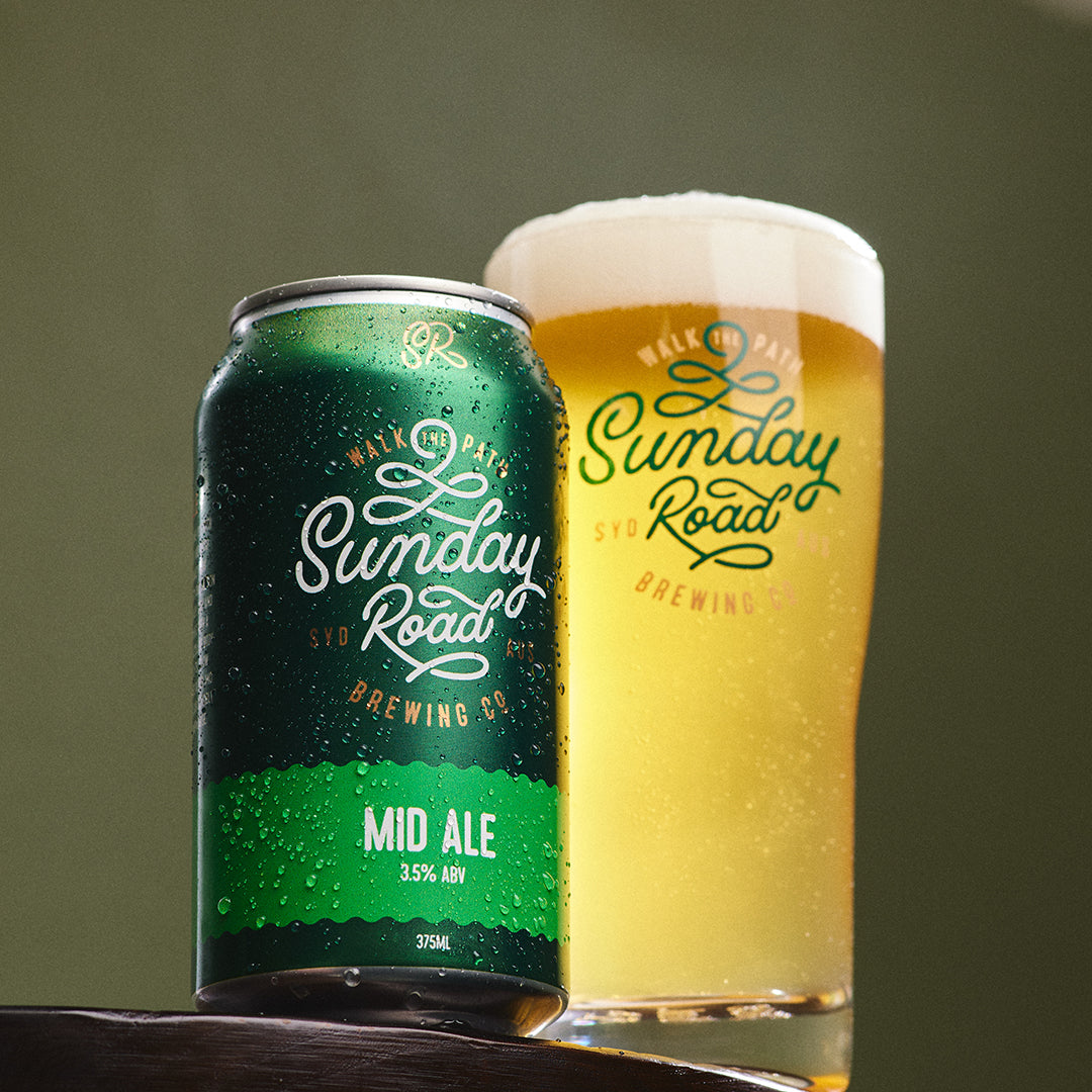 Green can and glass of Sunday Road Mid Ale on a wooden surface with a green background in kirrawee taproom