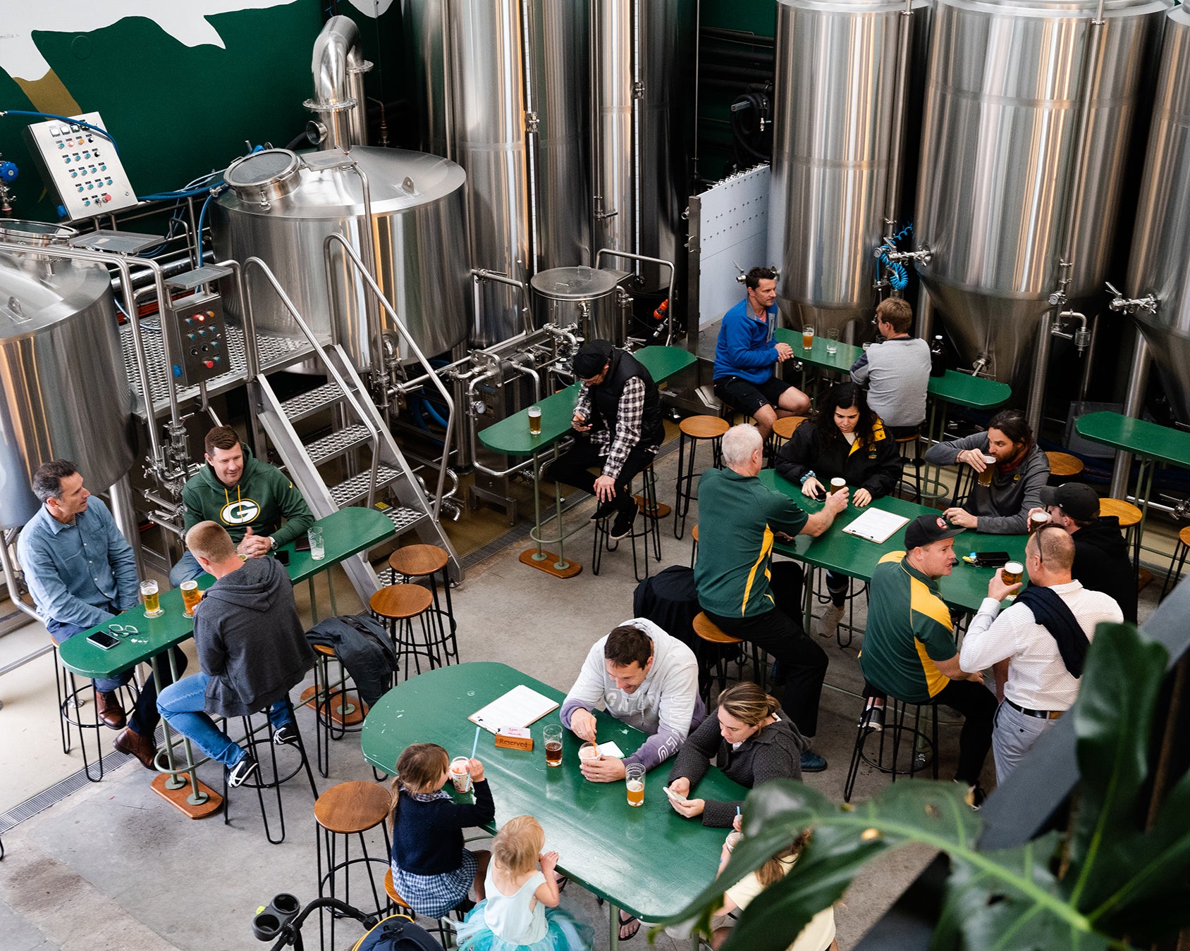 Group of people sitting around a table in the sunday road taproom brewery in kirrawee sutherland shire with beer glasses and food.