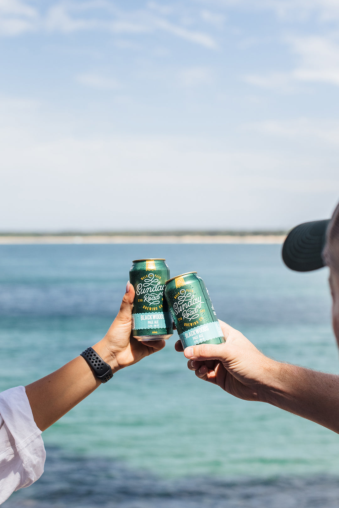 sunday road brewing beer cans blackwoods pale ale being cheered at the beach